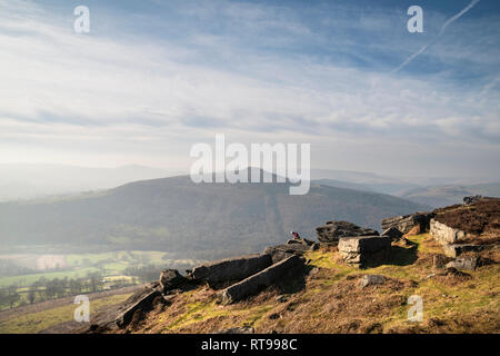 Grimpeurs sur Bamford Edge dans le Peak District, surplombant le paysage vers perdre Hill et Mam Tor dans la distance, un jour d'hiver Banque D'Images