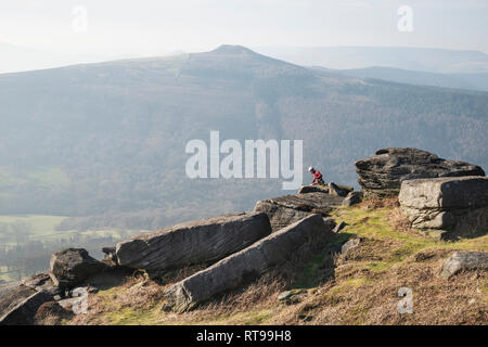 Grimpeurs sur Bamford Edge dans le Peak District, surplombant le paysage vers perdre Hill et Mam Tor dans la distance, un jour d'hiver Banque D'Images