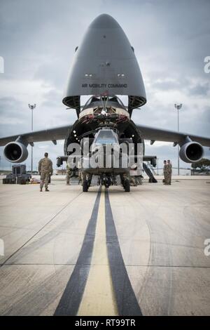 La station navale de Rota, Espagne (30 janvier 2019) soldats affectés à la 1ère division blindée et Théâtre 1109th Soutien Aviation Maintenance Group chargement d'un hélicoptère Apache AH-60 sur un avion C-5 pendant les opérations intermodales. Combiner les opérations intermodales de transport maritime et aérien pour réduire la manutention du fret, d'améliorer la sécurité, réduire les dommages et permettre le transport plus rapide. Banque D'Images