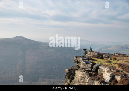 Grimpeurs sur Bamford Edge dans le Peak District, surplombant le paysage vers perdre Hill et Mam Tor dans la distance, un jour d'hiver Banque D'Images