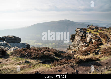 Grimpeurs sur Bamford Edge dans le Peak District, surplombant le paysage vers perdre Hill et Mam Tor dans la distance, un jour d'hiver Banque D'Images