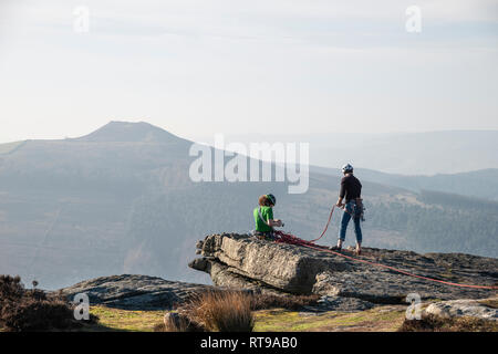 Grimpeurs sur Bamford Edge dans le Peak District, surplombant le paysage vers perdre Hill et Mam Tor dans la distance, un jour d'hiver Banque D'Images