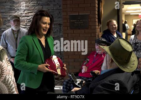 Gouverneur du Michigan Gretchen Whitmer reçoit un don de Rob Troost, ancien combattant et président de l'avocat du député au Grand Rapids Accueil pour les anciens combattants. Elle, lui et le lieutenant gouverneur Garlin Gilchrist et le Major général Paul Rogers, adjudant général de l'État du Michigan, a visité les installations et rencontré les membres qui y résident. La Garde Nationale (Michigan) Banque D'Images