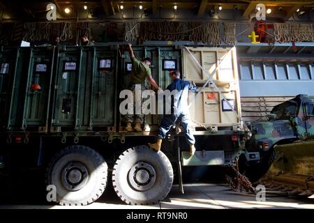 Le Cpl. Guereca Hector et lance le Cpl. Corey Hutchings, opérateurs de transport à moteur avec le 31 bataillon de logistique de combat les conteneurs d'expédition de la chaîne d'un camion 7 tonnes à bord du navire de débarquement dock USS Ashland (LSD 48), mer des Philippines, le 31 janvier 2019. Guereca, originaire de San Antonio, est diplômé de l'école secondaire Marshall en juin 2014 avant de s'enrôler en janvier 2017. Hutchings, originaire de Bradford, en Pennsylvanie, est diplômé de l'école secondaire de Bradford en juin 2016 avant de s'enrôler en décembre de la même année. Bec-31 fournit la sécurité, la logistique, le transport, et l'appui logistique que l'HADR Élément Combat fo Banque D'Images