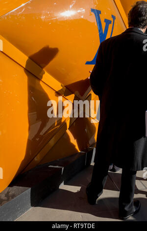 Associates de tenir une conversation après spontanément en heurtant les uns les autres sous l'amassage de rénovation temporaire de la marque de luxe Louis Vuitton à New Bond Street, le 27 février 2019, à Londres, en Angleterre. Banque D'Images