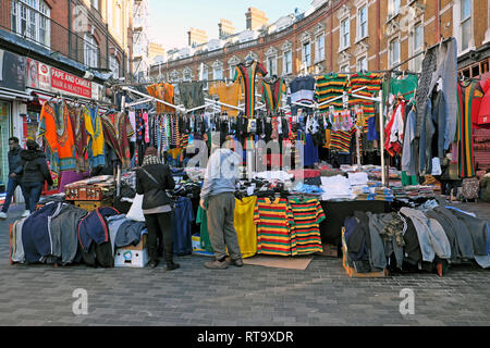 Un commerçant du marché de vente de vêtements pour hommes l'homme à Brixton street market scene Electric Avenue South London England UK Brixton KATHY DEWITT Banque D'Images