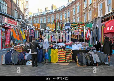 Un commerçant du marché de vente de vêtements pour hommes l'homme et maillots de football à Brixton street market Electric Avenue Brixton sud de Londres Angleterre Royaume-uni KATHY DEWITT Banque D'Images