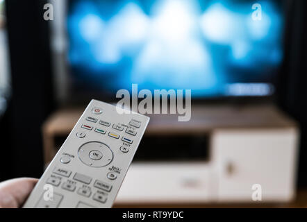 L'homme avec la télécommande dans la main en regardant la télé Banque D'Images