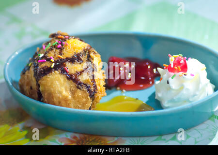 La crème glacée frite avec garniture au chocolat et sauce aux fraises Banque D'Images
