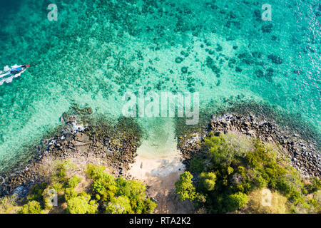 Vue de dessus, vue aérienne d'un bateau traditionnel à proximité de une magnifique barrière de corail avec une belle petite plage. Banque D'Images