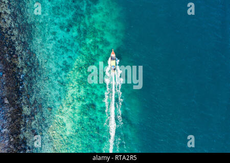 Vue de dessus, vue aérienne d'un bateau traditionnel à proximité de une magnifique barrière de corail avec une belle petite plage. Banque D'Images