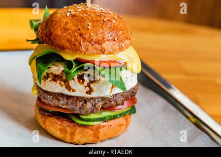 Close up tall tasty burger avec fromage servi sur le bac Banque D'Images