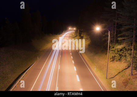 Une longue exposition photo de trafic avec des traces floues des voitures de nuit en Finlande, vue d'en haut. Banque D'Images