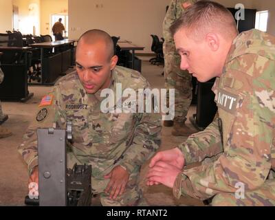 Réserve de l'armée américaine le s.. Vincent Schimke, instructeur pour l'opération Cold Steel III, montres Le Sgt. Carlos Rodriguez, un spécialiste des ressources humaines avec la 561 e Groupe de soutien régional, basé à Elkhorn, Neb., démonter un M2 mitrailleuse de calibre .50 lors de l'opération d'acier froid III entraînement à Fort Hunter Liggett, Calif., le 7 février 2019. Les soldats doivent apprendre à démonter et effectuer la maintenance d'armes pour assurer leur fonctionnement au cours d'opérations de combat. L'acier froid Fonctionnement III les trains et les soldats de la réserve de l'admissibilité sur M2, mitrailleuses de calibre .50 M19 40 mm la grenade automatique Banque D'Images