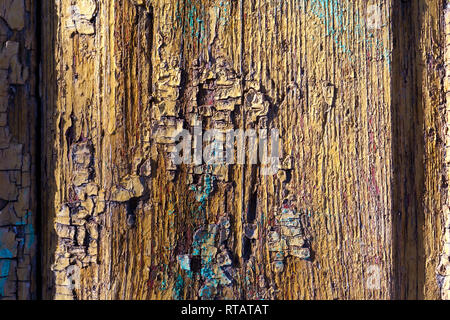 La texture de fond est une vieille surface en bois peint avec des squames jaune, mauve, bleu et marron peinture. Texture background coloré en bois Banque D'Images