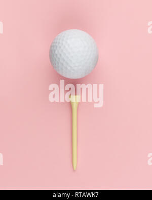 Balle de Golf tee en bois et sur fond rose closeup
