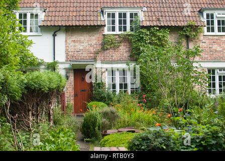 Style traditionnel anglais jardin de devant en milieu rural en été avec Kent House, porte rouge et grimpeurs, près de l'AONB High Weald area. Vu lors d'une randonnée. Banque D'Images