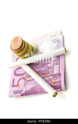 Euro argent et cigarettes isolated over white background. Concept d'habitude de fumer coûte cher. Banque D'Images