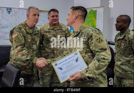 Le Lieutenant-colonel de l'armée américaine Steven Templeton, commandant du 3e Bataillon d'hélicoptères d'assaut, 4e Régiment d'aviation de l'aviation de combat, 4e Brigade, 4e Division d'infanterie, présente un certificat de colonel de l'armée américaine Dale Murray, commandant de la région de la mer Noire, l'équipe de soutien pour leur soutien durant la rotation de l'unité à l'appui de l'opération Atlantic résoudre à la base aérienne de Mihail Kogalniceanu, Roumanie, 7 février 2019. Tourner les unités de bases en position stratégique en Europe fréquemment afin de former avec des partenaires et des alliés et de dissuader les éventuels d'agression dans la région. Banque D'Images