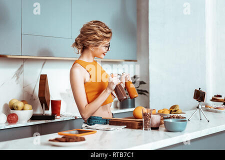 Nice agréable woman holding bouteilles de smoothie Banque D'Images