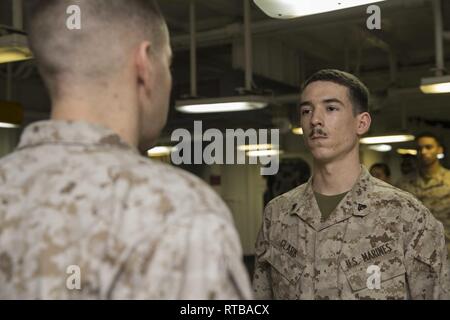 Le Sgt. Jamieson Clarke, droite, un directeur juridique avec la 22e Marine Expeditionary Unit est de l'attention en face de son agent de promotion, le Major Micah Penn, gauche, la 22e MEU Juge-avocat personnel, dans le fo'c'sle, ou gaillard, de l'USS Kearsarge LHD (3), le 2 février 2019. Marines et de marins avec la 22e Marine Expeditionary Unit et groupe amphibie Kearsarge sont déployés dans le domaine de la 5e flotte américaine des opérations à l'appui des opérations navales pour assurer maritme la stabilité et la sécurité dans la région Centrale, reliant la Méditerranée et le Pacifique à travers l'ouest de l'Océan indien et Banque D'Images