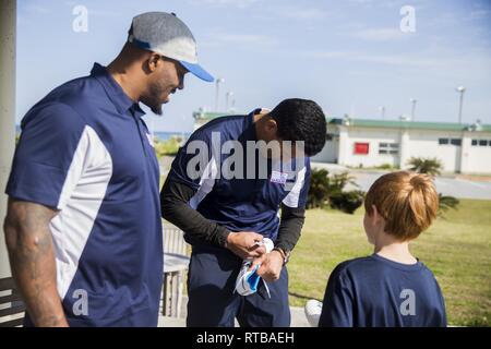 NFL alumni Donnie Edwards et Steven Jackson manuscrit un taquet de football de jeunes fans le 3 février 2019, à l'USO sur Camp Kinser, Okinawa, Japon. L'USO invité Edwards et Jackson à la visite des installations militaires à Okinawa, au Japon afin de visiter les membres de service et pour le moral au cours de la hauteur de la saison de football. Banque D'Images