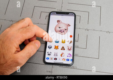 PARIS, FRANCE - NOV 9 2017 : sélection de la main de l'homme animoji cochon suspectes générées par emoji Face ID système de reconnaissance faciale avec émotion visage malveillant close-up du nouvel iphone X 10 Afficher Banque D'Images