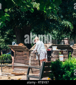 PARIS, FRANCE - 24 juin 2017 : les femmes adultes le compostage en milieu urbain dans les espaces dédiés dans la capitale française. Les gens le compostage mise en dépôt des déchets recyclage composteur. Banque D'Images