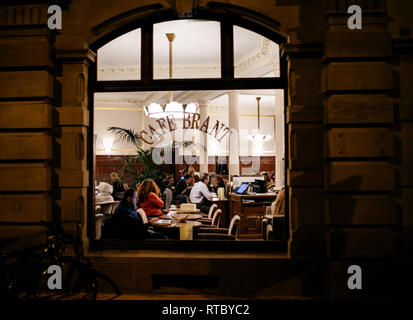 STRASBOURG, FRANCE - NOV 21, 2017 : les touristes et les habitants de boire un café bien chaud ou un thé à l'intérieur du café Brant à Strasbourg - vue de la rue la nuit Banque D'Images