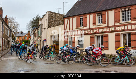 Dampierre-en-Yvelines, France - le 4 mars 2018 : le peloton passe devant des bâtiments traditionnels sur une petite rue dans un village français au cours de Pari Banque D'Images