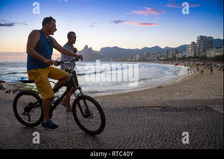 RIO DE JANEIRO - le 22 février 2017 : Les gens passent en silhouette sur la promenade de l'Arpoador, Rocky Point à la fin de la plage d'Ipanema. Banque D'Images