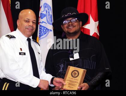 Le major-général John C. Harris Jr. (à gauche), adjudant général de l'Ohio, remet une plaque de reconnaissance à Zayne Harshaw, guitariste de Columbus, Ohio, blues band spectre bleu, pour son soutien au cours de la Garde nationale de l'Ohio l'égalité des chances, la diversité et l'intégration du Bureau Africain/Mois de l'histoire des Noirs le 12 février, 2019 respect, au major-général Robert S. Beightler Armory à Columbus. Harshaw a joué un ensemble de jazz, blues et rock classique au cours du programme. Banque D'Images