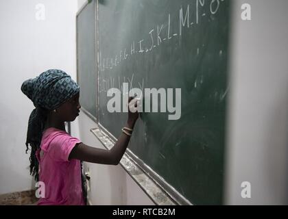 Un enfant écrit l'alphabet au cours d'une discussion en anglais groupe mené par des soldats de l'Armée américaine du 404e Bataillon des affaires civiles, affecté à la Force opérationnelle combinée Force-Horn de l'Afrique, à Tadjoura, Djibouti, le 12 février 2019. Plus de 90 jeunes et adultes djiboutienne est allé(e) à un groupe où les élèves à développer des compétences pratiques et linguistiques par le biais de conversations avec rhétorique anglophones membres service aux États-Unis. Banque D'Images