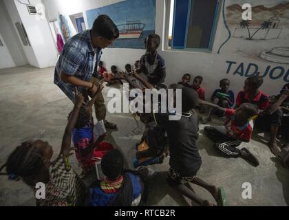 Le sergent de l'armée américaine. Brian Zimmerman, un sous-officier des opérations du 403e Bataillon des affaires civiles, affecté à la Force opérationnelle combinée Force-Horn de l'Afrique, travaille avec les enfants au cours d'une Discussion en groupe anglais Tadjourah, Djibouti, le 12 février 2019. Plus de 90 jeunes et adultes djiboutienne est allé(e) à un groupe où les élèves à développer des compétences pratiques et linguistiques par le biais de conversations avec rhétorique anglophones membres service aux États-Unis. Banque D'Images