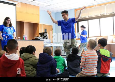 CAMP HUMPHREYS, République de Corée - Le Lieutenant-colonel Min Kim, Philadelphie, Pennsylvanie, natif pédodontiste, 618e compagnie du service dentaire, 65e brigade médicale, sensibilise les élèves de seconde sur le processus d'obtenir les dents adultes et l'importance de la santé dentaire à l'École élémentaire centrale Humphrey, 13 février. Respect des droits de l'enfant dans le mois de la santé dentaire, les soins dentaires 618e Co., 65e brigade médicale dentistes participants et fourni le dépistage dentaire et d'éducation en santé buccodentaire auprès des élèves du cycle primaire au Camp Humphreys tout au long de février. Banque D'Images