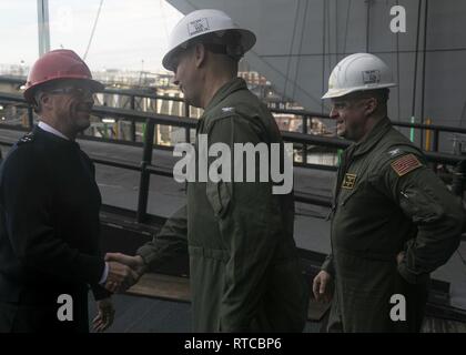 NEWPORT NEWS, Virginie (fév. 13, 2019) Le capitaine John J. Cummings, USS Gerald R. Ford (CVN 78) commandant du centre, et le Capitaine Tim attend, Ford de la direction, droite, greet French Vice-Adm. Jean-Philippe Rolland, commandant de la Force d'action navale, marine nationale, sur Ford de dunette au cours d'une visite à bord de Ford. Ford est actuellement en post-shakedown la disponibilité de Huntington Ingalls Industries-Newport News Shipbuilding. Banque D'Images