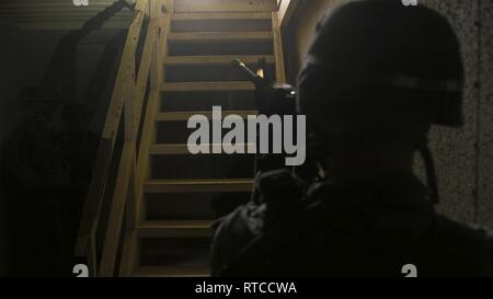 Un policier militaire du bataillon logistique de combat avec 31 montres l'escalier pendant les opérations militaires en territoire urbain formation à la lutte contre la ville, Okinawa, Japon, le 13 février 2019. La 31e unité expéditionnaire de marines, le Corps des Marines' seulement continuellement de l'avant-MEU déployée en partenariat avec Wasp groupe amphibie, fournit un moyen souple et la force meurtrière prêt à réaliser une vaste gamme d'opérations militaires comme la première force d'intervention de crise dans la région Indo-Pacifique. Banque D'Images