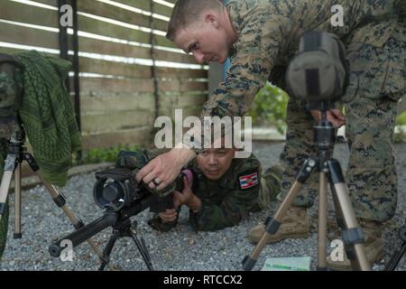 Le Sgt. Wyatt D. Vass indique à une Marine royale thaïlandaise pendant un incendie réel cas d'or Cobra 19, camp de Ban Chan Khrem, Khao Khitchakut District, Thaïlande, le 13 février 2019. Gold Cobra exercice démontre l'engagement du Royaume de Thaïlande et des États-Unis à notre alliance de longue date, fait la promotion des partenariats régionaux et les progrès de la coopération en matière de sécurité dans la région Indo-Pacifique. Vass, originaire de Palm Springs, Californie et le chef scout sniper avec des armes, de l'entreprise Équipe de débarquement du bataillon, 1er Bataillon, 4ème Marines, est diplômé de l'école secondaire de Palm Springs en juin 2013 avant de s'enrôler en nov. Banque D'Images