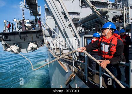 Océan Pacifique (fév. 15, 2019) Jonathan Marin Castillo, de Garfield, New Jersey, heaves line comme marins un inférieur à coque rigide à bord de la classe de Harpers Ferry landing ship dock amphibie USS Harpers Ferry (LSD 49) pendant les opérations de bateau. Harpers Ferry est en cours, la réalisation des opérations de routine dans le cadre d'un groupe amphibie USS Boxer (ARG) dans l'océan Pacifique. Banque D'Images