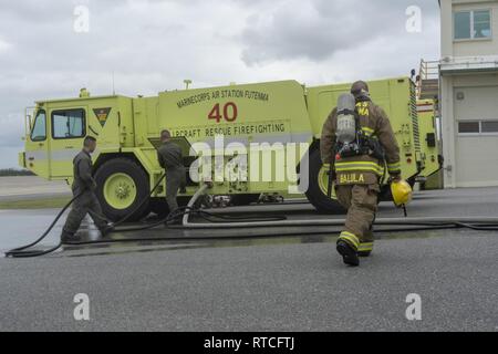 Avec des Marines de Futenma Marine Corps Air Station Crash, Fire and Rescue pack jusqu'le flexible 16 février à la caserne le MCAS Futenma. Les Marines ont démontré comment utiliser correctement le flexible d'éteindre les différents types d'incendies. Banque D'Images