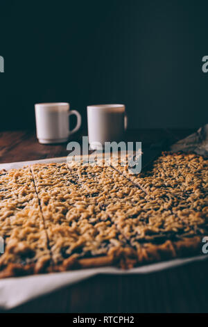 Close-up composé de biscuits viennois couper en carrés à côté de deux tasses de café. Banque D'Images