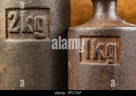 Old rusty poids en métal pour le pesage des produits. Accessoires pour la détermination du poids. Fond sombre. Banque D'Images