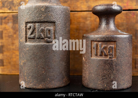 Old rusty poids en métal pour le pesage des produits. Accessoires pour la détermination du poids. Fond sombre. Banque D'Images