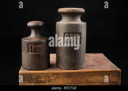 Old rusty poids en métal pour le pesage des produits. Accessoires pour la détermination du poids. Fond sombre. Banque D'Images