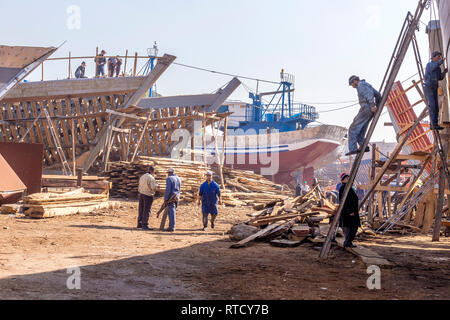 Les charpentiers au travail à l'aide d'outils simples pour construire des bateaux de pêche en bois à la main Banque D'Images