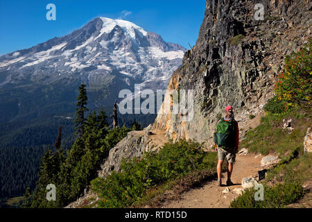 WA15825-00...WASHINGTON - Randonneur sur le sentier de Pinnacle Peak avec vue sur le mont Rainier dans le Parc National de Mount Rainier. Banque D'Images