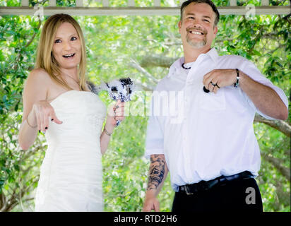 Les nouveaux mariés rire comme ils parlent après leur cérémonie de mariage au parc Marshall à Ocean Springs, Mississippi. Banque D'Images