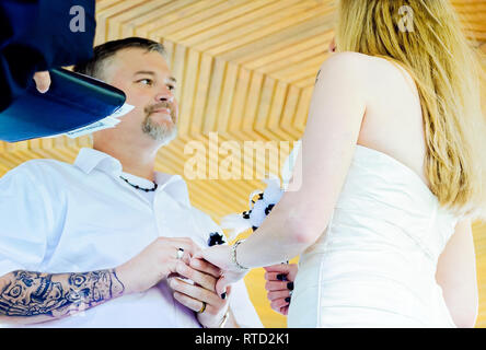 Un couple échange des vœux de mariage à un mariage en plein air au parc Marshall à Ocean Springs, Mississippi. Banque D'Images