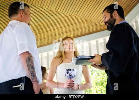 Un couple échange des vœux de mariage à un mariage en plein air au parc Marshall à Ocean Springs, Mississippi. Banque D'Images