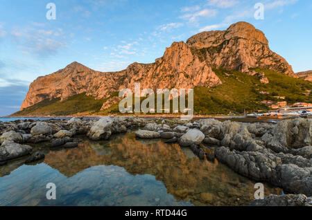 Beaux nuages épars au coucher du soleil à Barcarello, avec le promontoire de Capo Gallo reflétée sur l'eau calme. Palerme, Sicile. Banque D'Images